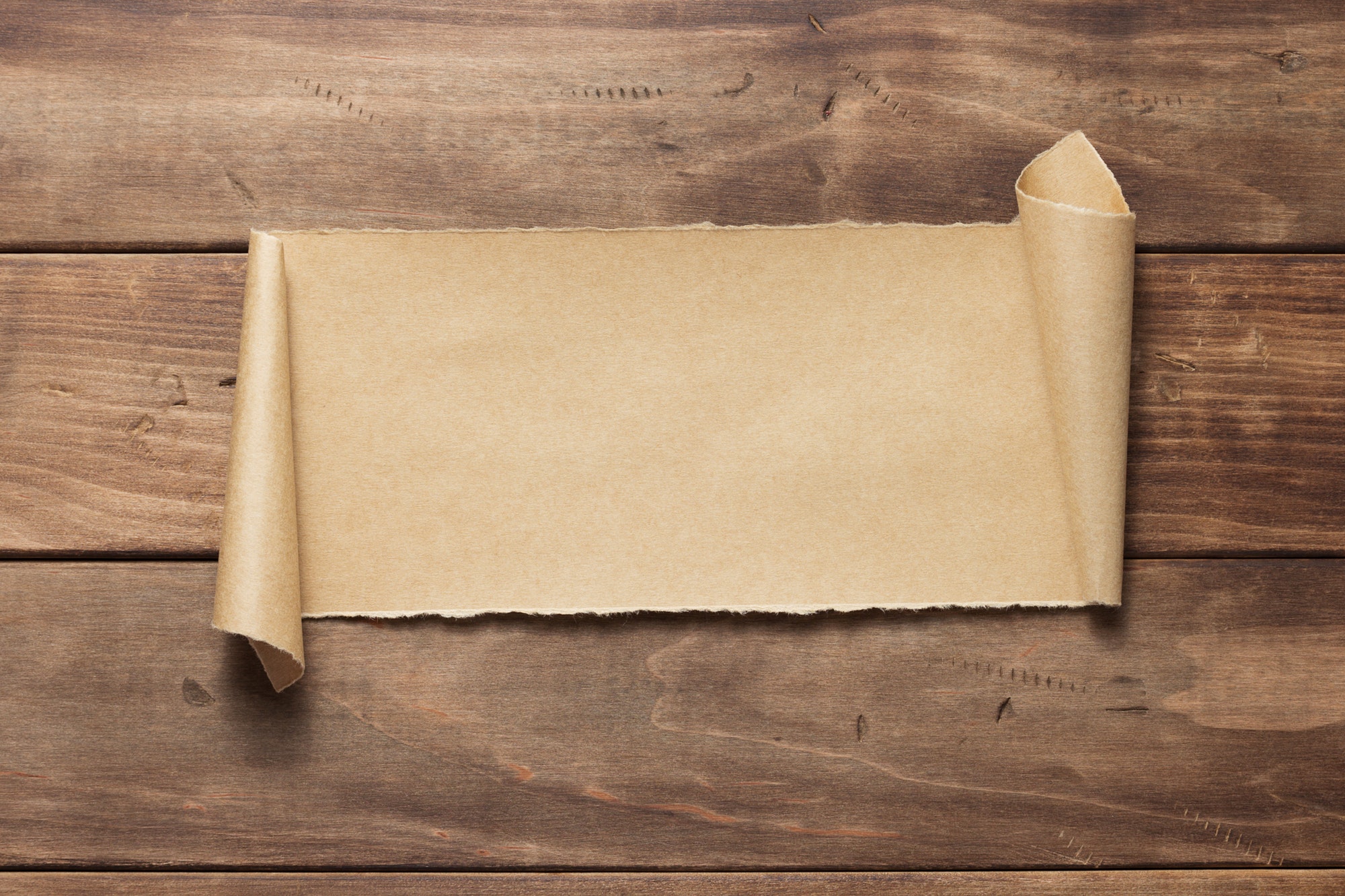 curved or scrolled paper on wooden background
