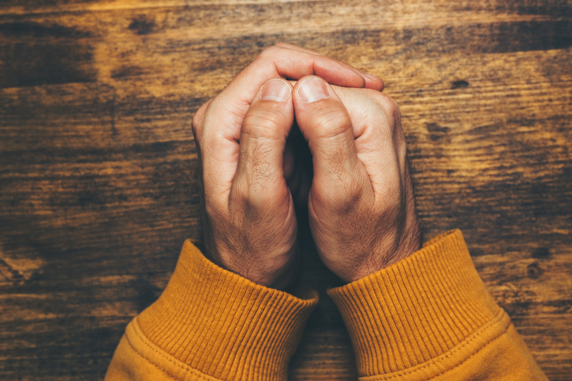 Top view of religious male crossed hands in prayer