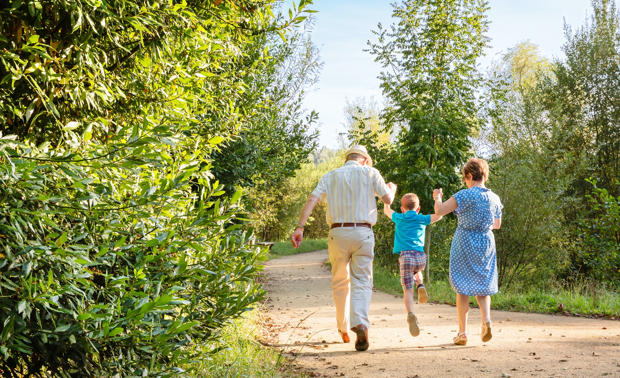 Grandparents and grandchild jumping outdoors