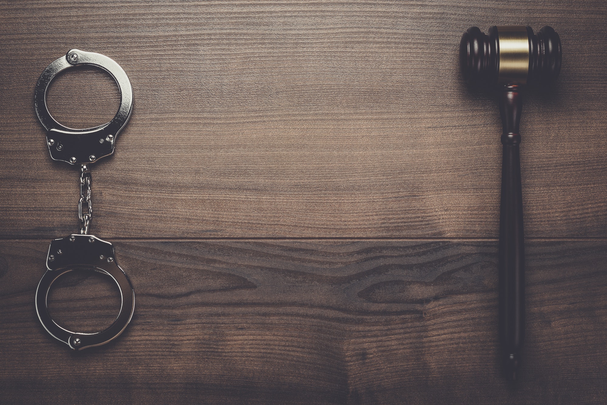 handcuffs and judge gavel on wooden background