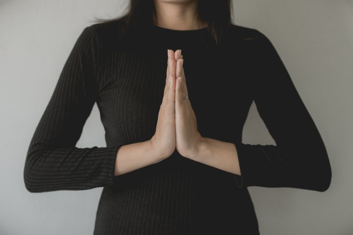 Asian woman with hand in praying position