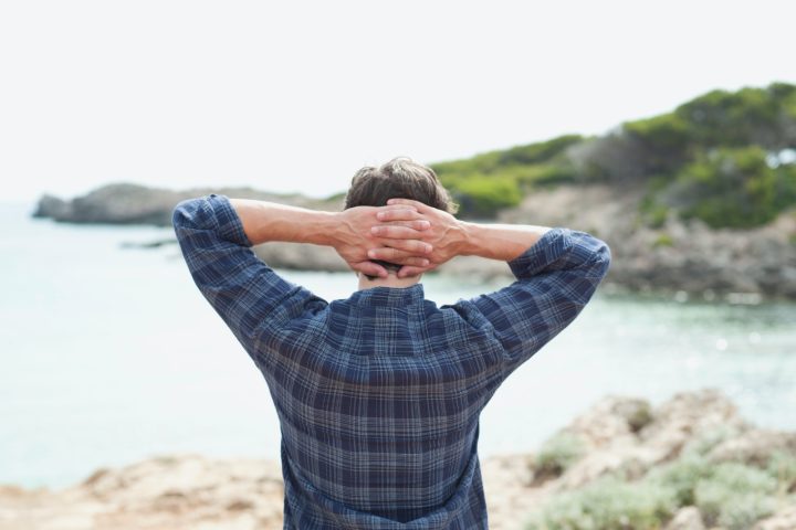 man looking at coastline