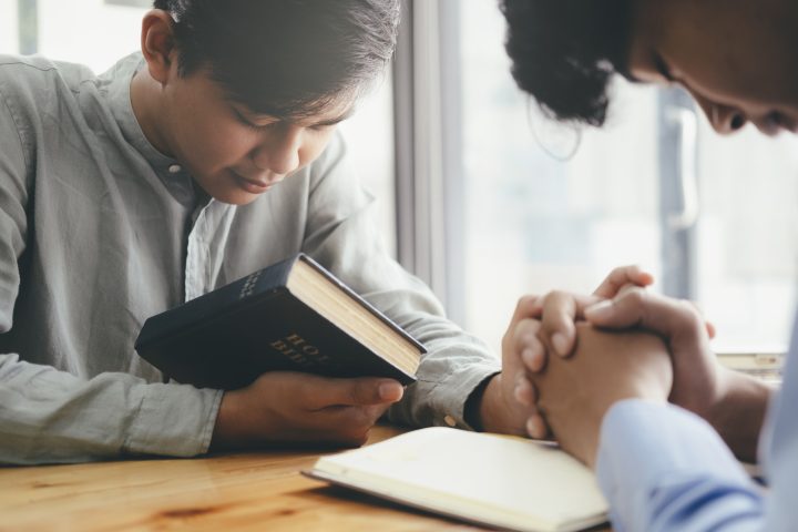 Two men praying for each other.